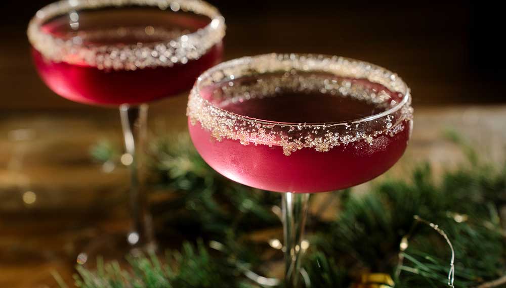 2 red holiday cocktails with a sugar rim